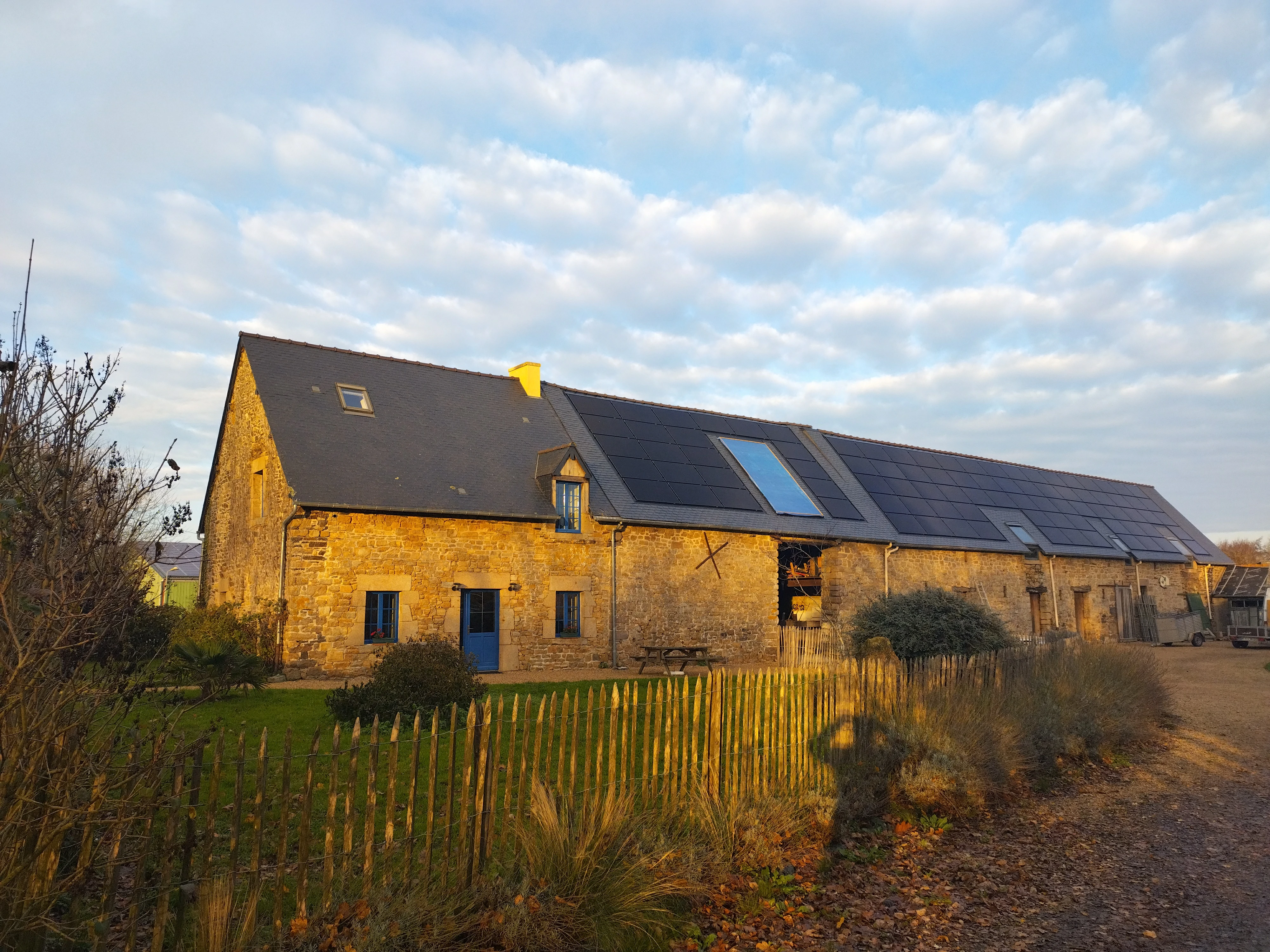 Travaux terminés sur la couverture en ardoise d'une ferme rénovée, réalisée par Couverture Delalande. Les panneaux solaires sont intégrés à la toiture.